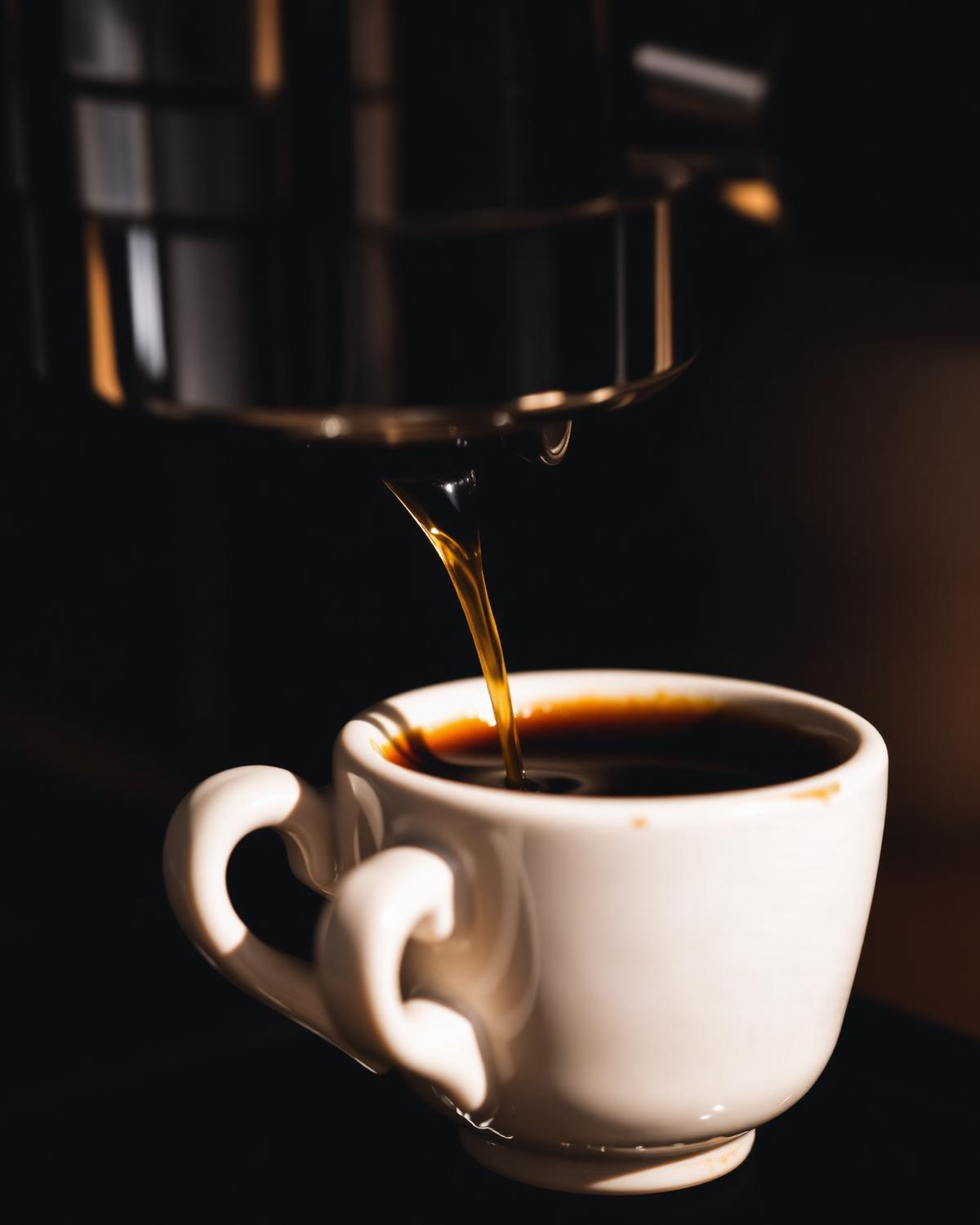 Espresso extraction into a small white cup